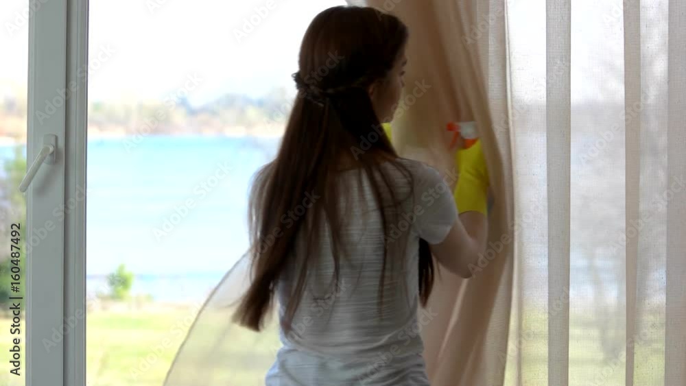 Woman cleaning window. Girl with bottle and rag. Woman cleaning window. Girl with bottle and rag.
