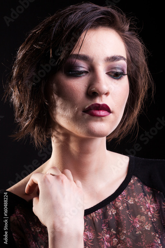 Seductive woman posing on black background in studio photo. Beauty and professional make-up