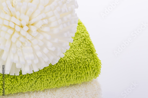 Loofah and green towel on white background