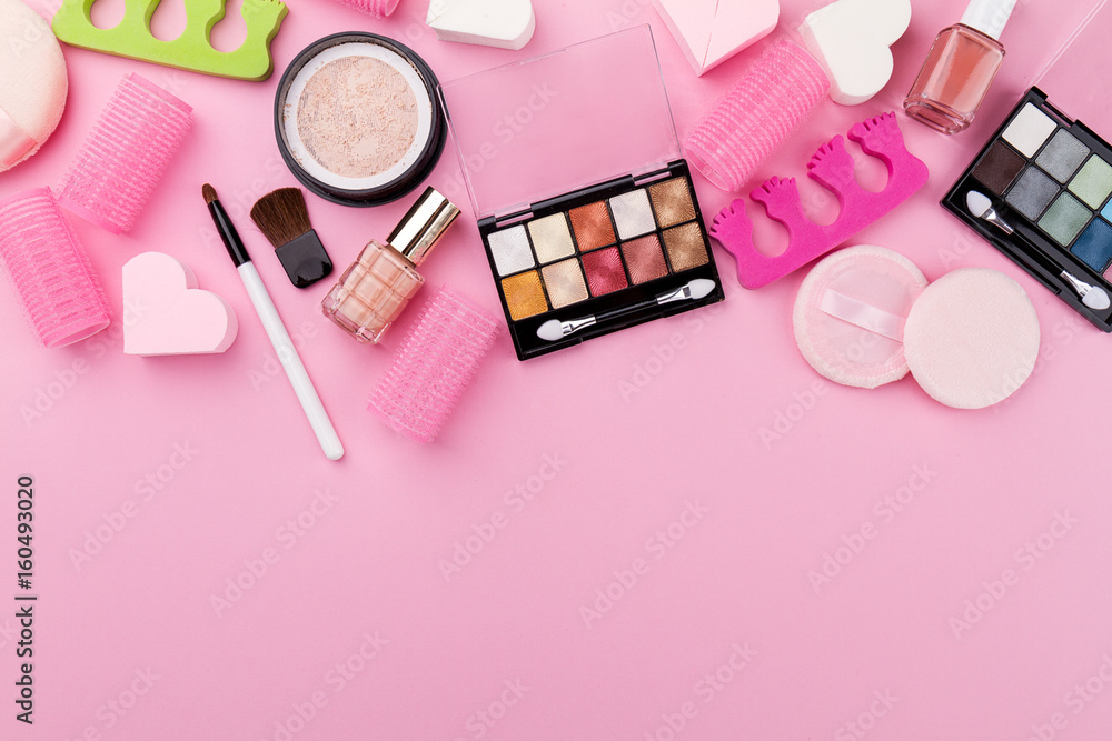 Fototapeta premium Beauty Spa Feminine Concept. Different Make Up Beauty Care Essentials Cosmetics on Flat Lay Pink Background. Top View. Above.