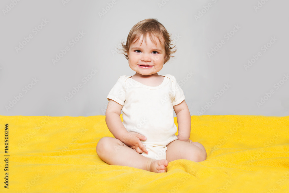  cheerful smiling  baby sitting on the bed
