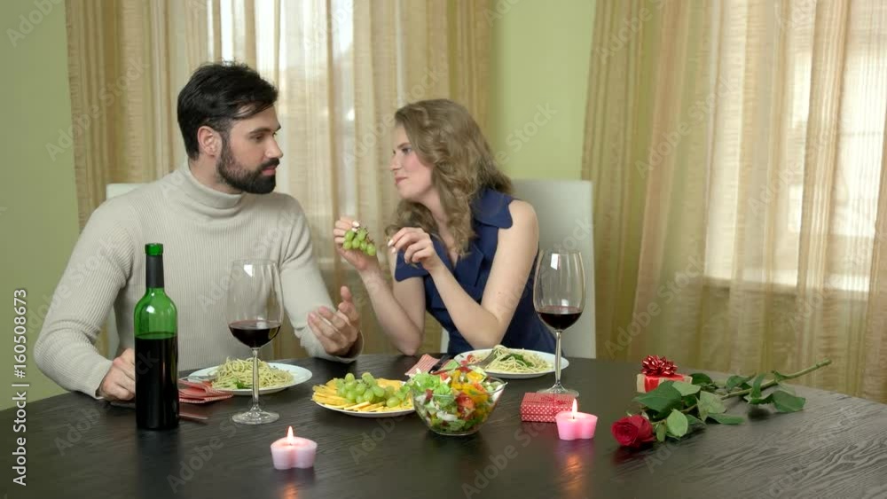 Woman feeding man grapes. Couple having a romantic dinner. Stock Video