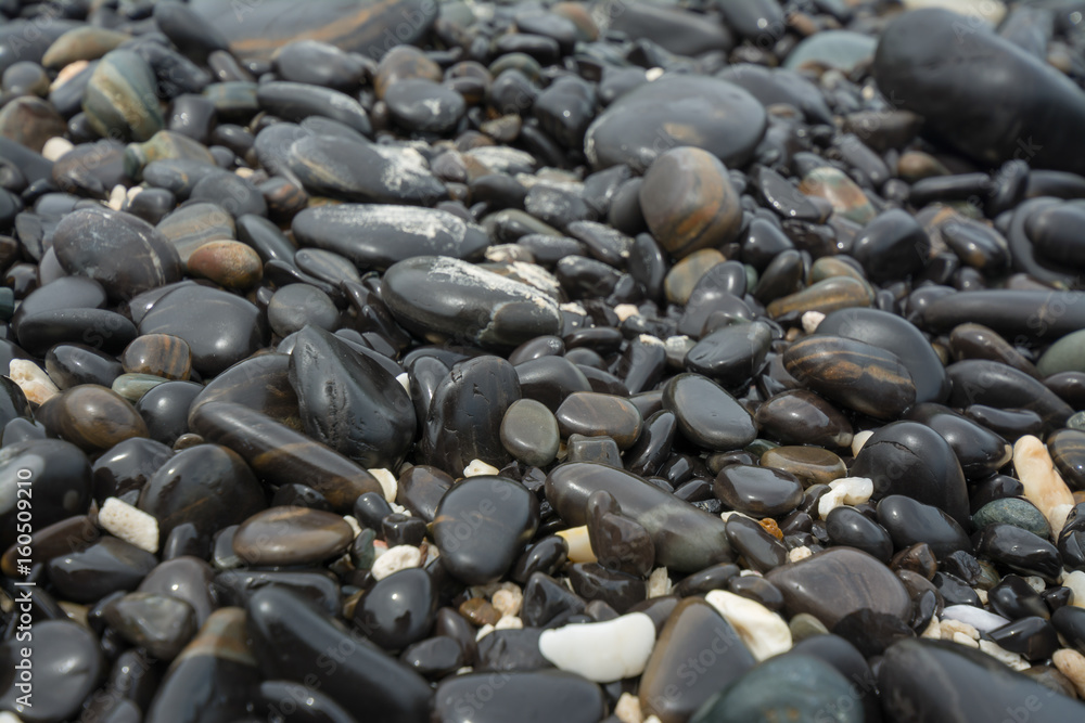 Black stones beach as a background. Black stones beach as a background.