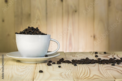 coffee beans in cup with wooden background and effect filter.