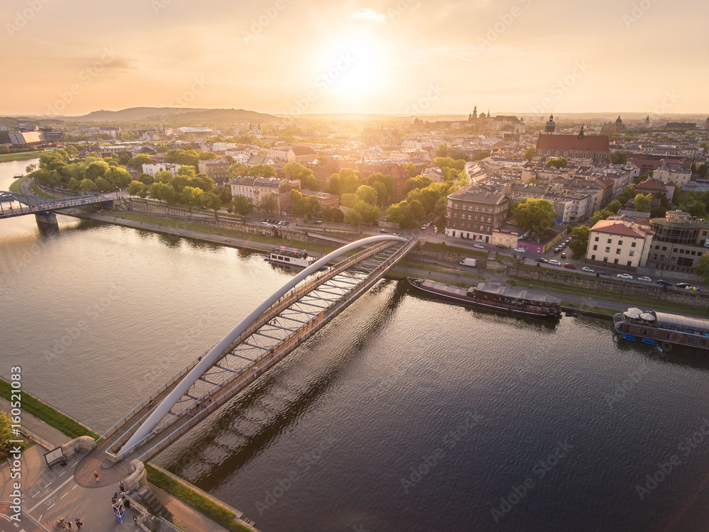 Stunning sumer sunset aerial view, people walking through Bernatka bridge over Vistula river in Krakow, Poland.