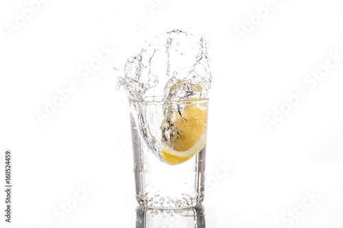 Lemon slice falls in a glass of water - Splash