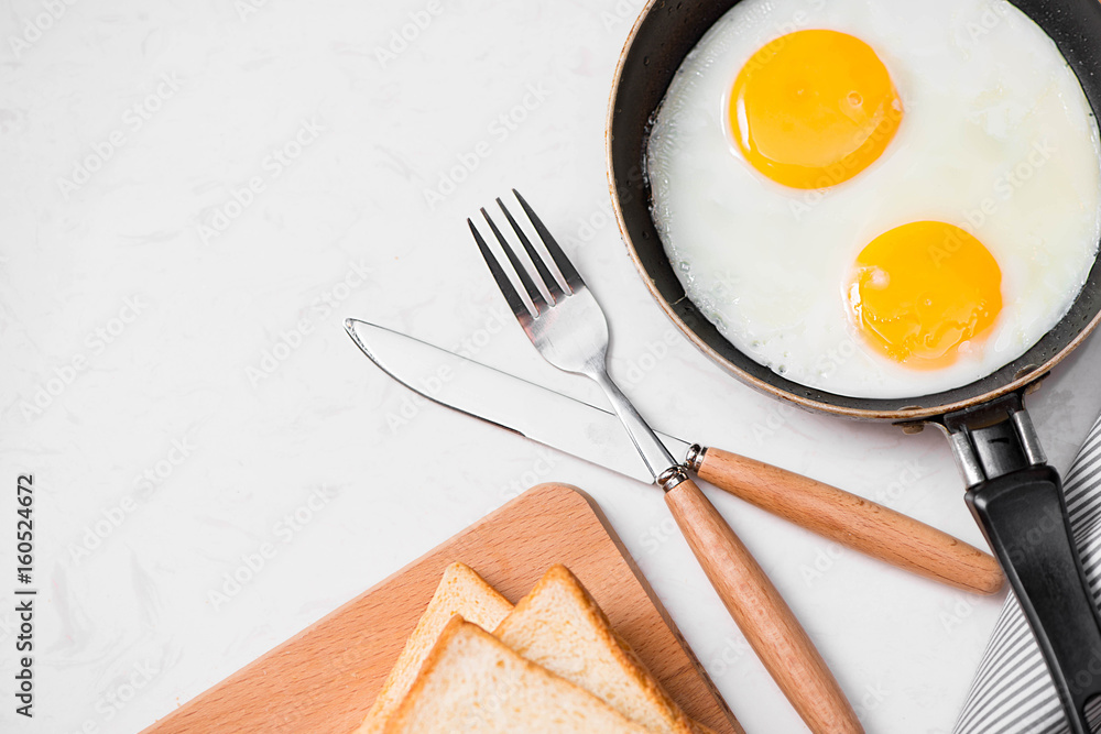 Top view of traditional healthy easy quick breakfast meal made of fried eggs served on a frying pan. Top view of traditional healthy easy quick breakfast meal made of fried eggs served on a frying pan.