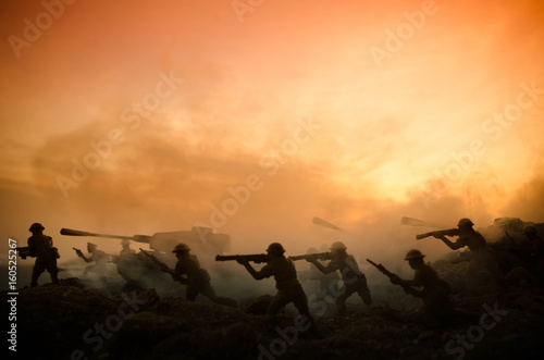 War Concept. Military silhouettes fighting scene on war fog sky background  World War Soldiers Silhouettes Below Cloudy Skyline At night. Attack scene. Armored vehicles. Tanks battle