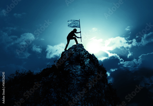 Фотография Man holding flag on the peak of mountain and sunrise outdoor on nature , success