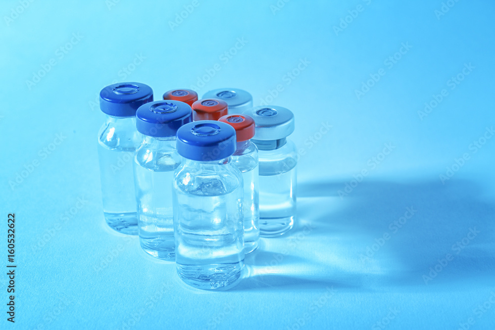 Medical ampules on colour background. Vaccination concept Medical ampules on colour background. Vaccination concept