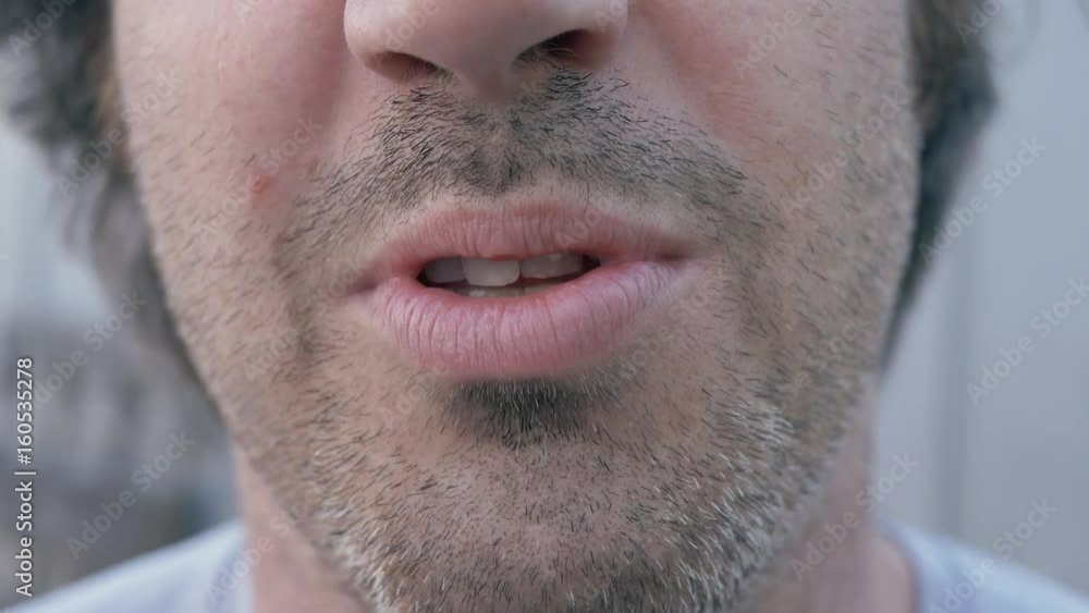 Man talking to the camera, focus on his mouth and unshaved face. Man talking to the camera, focus on his mouth and unshaved face.