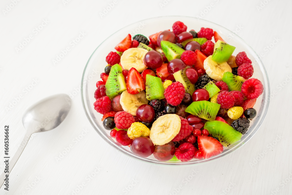Bowl of healthy fresh fruit salad on white wooden background. Top view. Bowl of healthy fresh fruit salad on white wooden background. Top view.