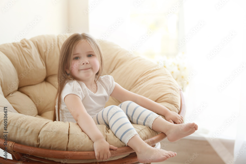 Cute little girl sitting on lounge at home Cute little girl sitting on lounge at home