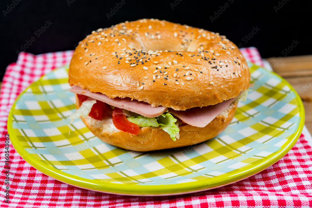 Bagel with fresh cheese and fresh lettuce on napkin Bagel with fresh cheese and fresh lettuce on napkin