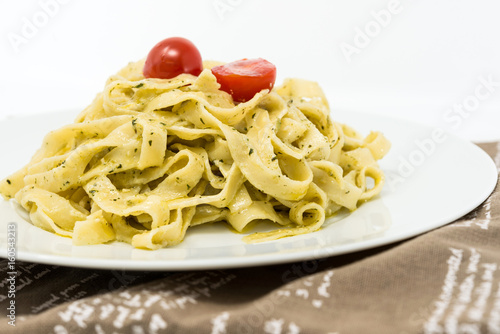 Pasta with pesto sauce and nuts on a the table