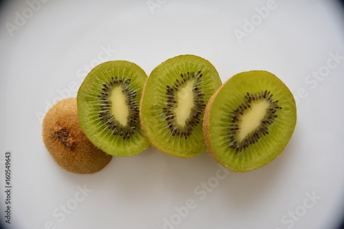 Kiwi cortado em três rodelas, fatias de kiwi, frutas, quivi, quiui, frutas verdes, sementes de kiwi photo
