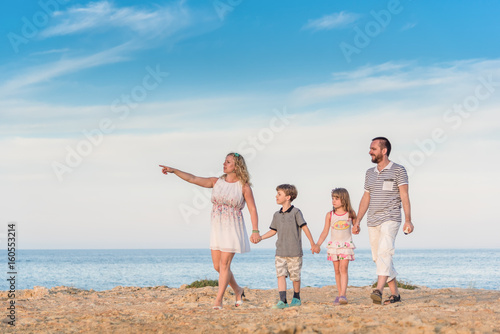 Family walking together alongside the sea