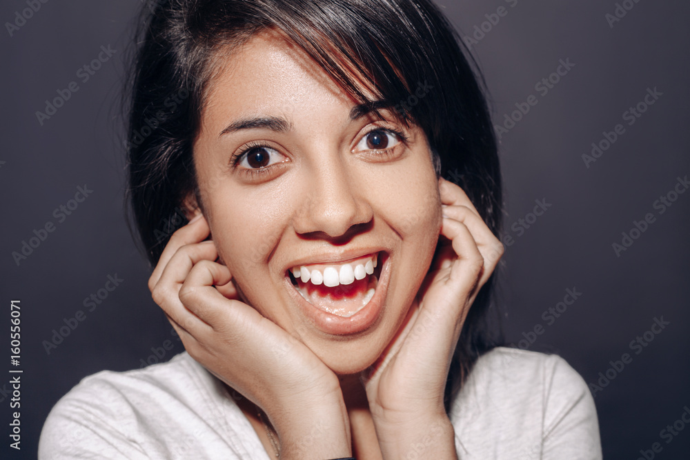 Closeup portrait of beautiful smiling young latin hispanic girl woman with long dark hair, brown black eyes in studio on plain black background, looking in camera, natural smile emotion Closeup portrait of beautiful smiling young latin hispanic girl woman with long dark hair, brown black eyes in studio on plain black background, looking in camera, natural smile emotion