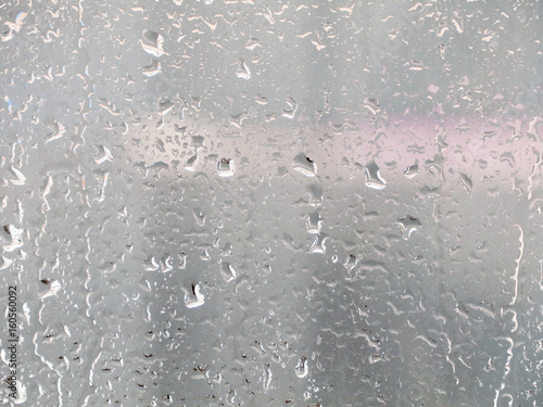 Rain drops on glass window. The cityscape outside the window in a blur. The bokeh effect.