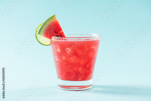 Glass of healthy watermelon juice in summertime on blue background.