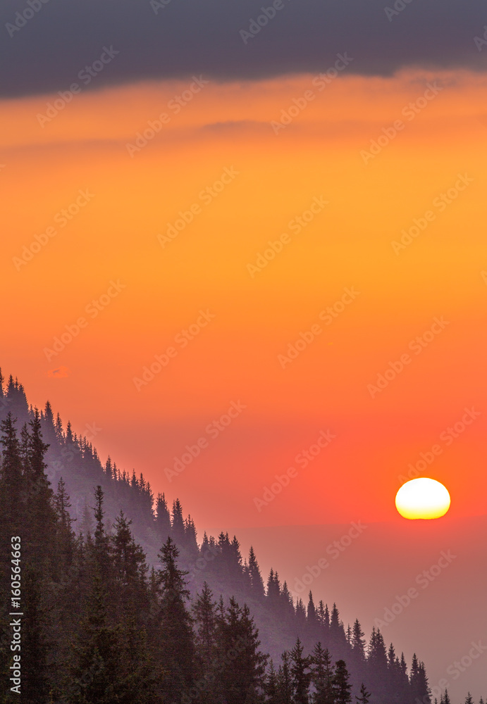 Obraz premium Sunset on the mountainside, orange sky