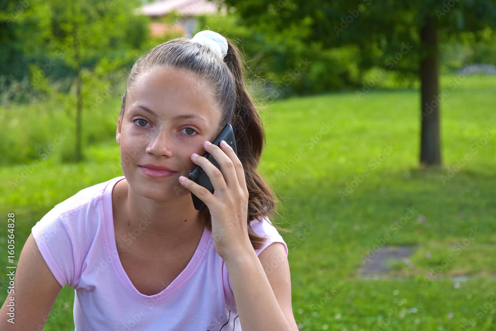 Young girl on green grass with phone Young girl on green grass with phone