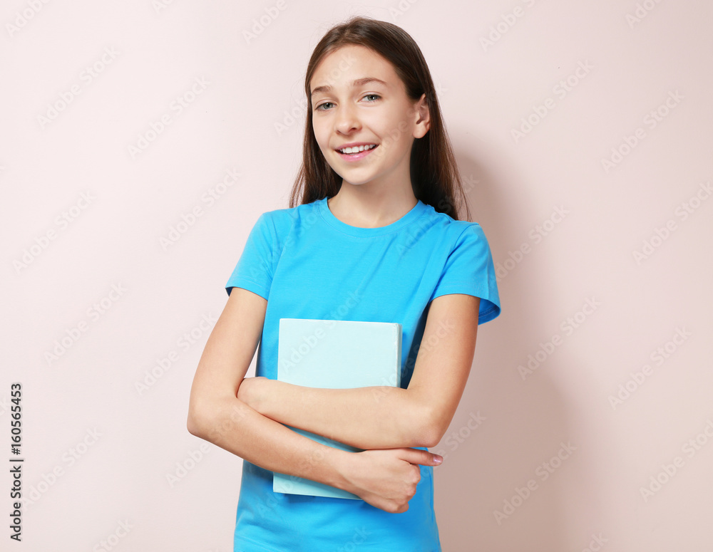 Cute pretty girl with book on color background