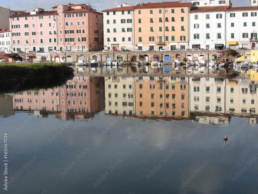 Picturesque ancient residential neighborhood near the city center of Livorno . Tuscany, Italy . Houses and boats are reflected in the tranquil water