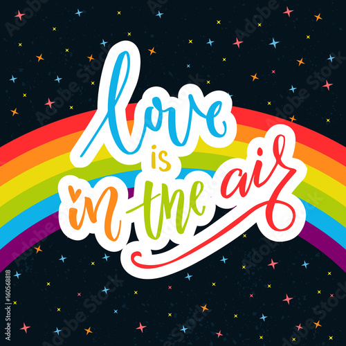 Love is in the air. Inspirational quote on rainbow parade flag at dark sky with stars. Gay pride saying for stickers, t-shirts and posters.