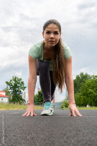 The girl is running around the stadium. Training outdoors. Front view