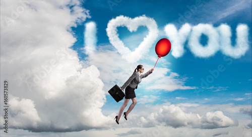 Woman flying balloons in romantic concept