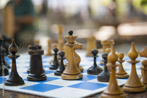 A chess game. Hand close-up taking a chess piece from a chessboard Сhess board with figure and Chess clock
