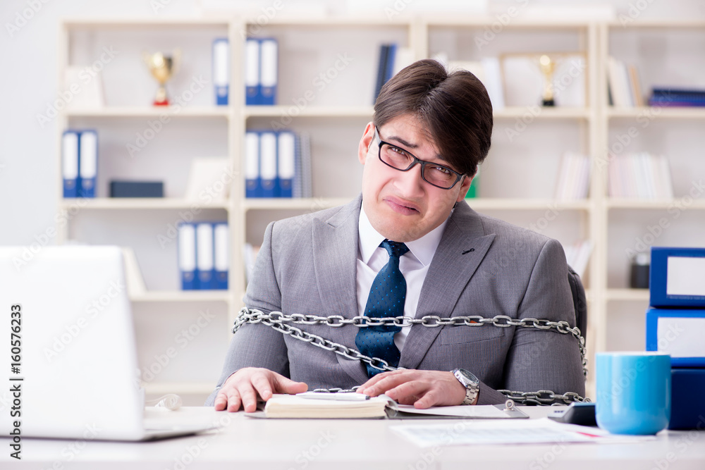 Businessman tied with chains to his work Businessman tied with chains to his work