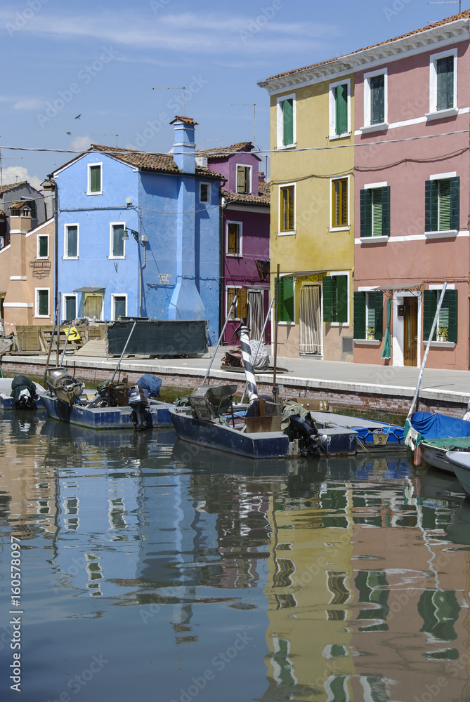 BURANO - ITALY, APRIL 18, 2009: Panoramic view of colorful buildings and boats in front of a canal at Burano, a gracious little town full of canals, near Venice.