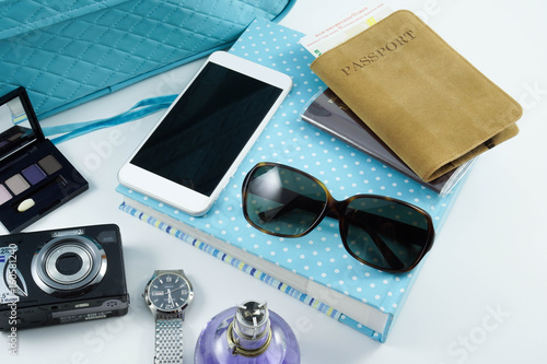 Traveling set, passport, sunglasses, camera, notebook, blue leather luggauge, cosmetics, parfume, watch on white background, a top view isoalted