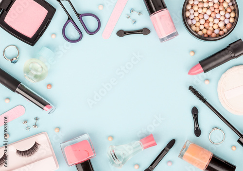 set of professional decorative cosmetics, makeup tools and accessory on blue background with copy space for your text. beauty, fashion, party and shopping concept. flat lay frame composition, top view