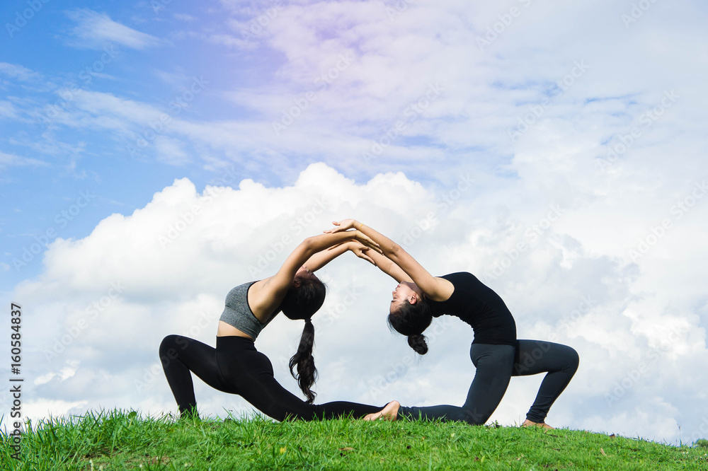 Fototapeta premium Woman practicing yoga relax in nature and blue sky background , Yoga Exercise Helps the mind to concentrate, calm and shape and healthy.
