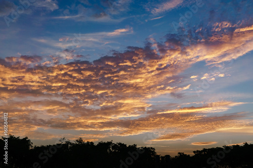 Fototapeta Naklejka Na Ścianę i Meble -  Golden hour Sun set in the evening reflecting orange on the clouds, nature background