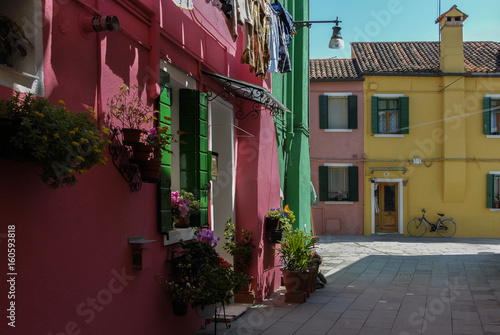 BURANO, ITALY - APRIL 18, 2009: Street with colorful buildings in Burano island, a gracious little town full of canals, near Venice - Italy 