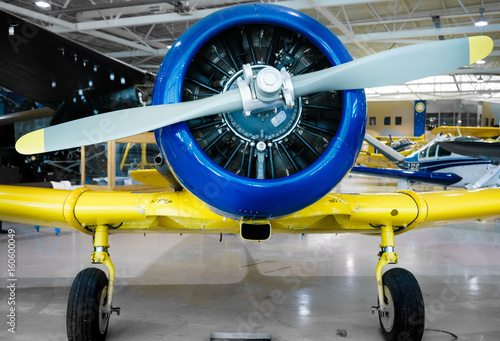 Front view of restored, stationary propeller aeroplane, indoors, at day. © bruno135_406