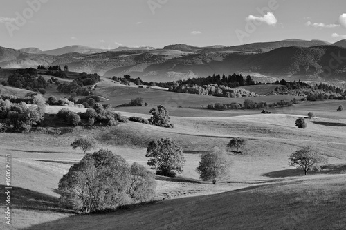 Spring forest and meadows landscape in Slovakia. Morning scenery near village Poniky. Fresh trees and pastures. Sunlit country. photo