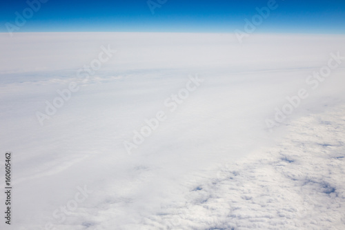 Above view of white clouds and a horizon with a blue sky. © Mariiam
