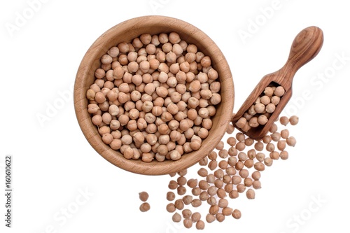 Chickpeas in a wooden plate and a wooden spoon on a white background