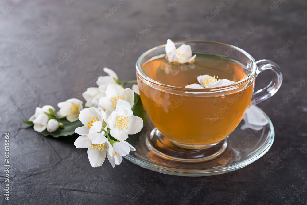 Jasmine tea with jasmine flowers on a dark background. Jasmine tea with jasmine flowers on a dark background.