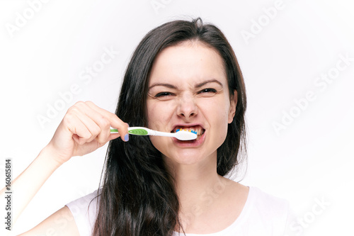 Woman brushing her teeth after eating on isolated background