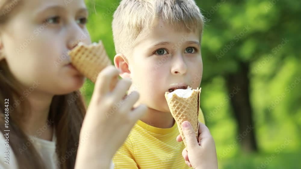 Children with icecream. A boy and a girl are eating ice cream in the park. Children with icecream. A boy and a girl are eating ice cream in the park.