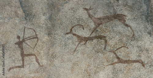 Drawings in a cave on a wall, a rock. Painted by a caveman. Ancient man hunting animals. Neanderthal, primitive. Petroglyphs.