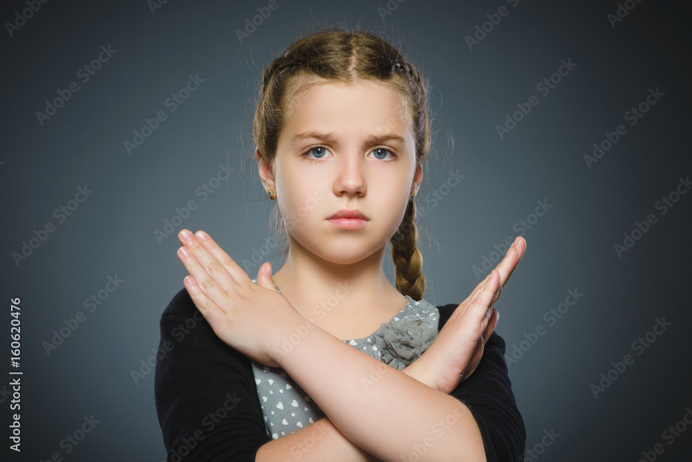 Serious girl making X sign with her arms to stop doing something Serious girl making X sign with her arms to stop doing something