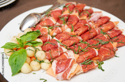 Tapas with cured ham, basil and melon balls