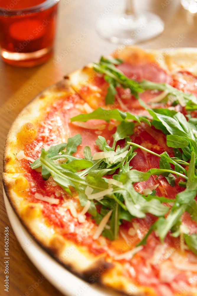 Mozzarella pizza with arugula salad on table Mozzarella pizza with arugula salad on table